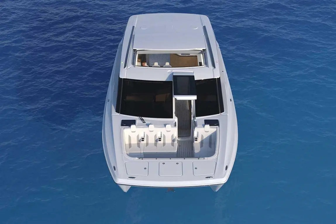 A sleek white boat with seating and a central console floats on clear blue water. Ideal for cruising or leisure activities.
